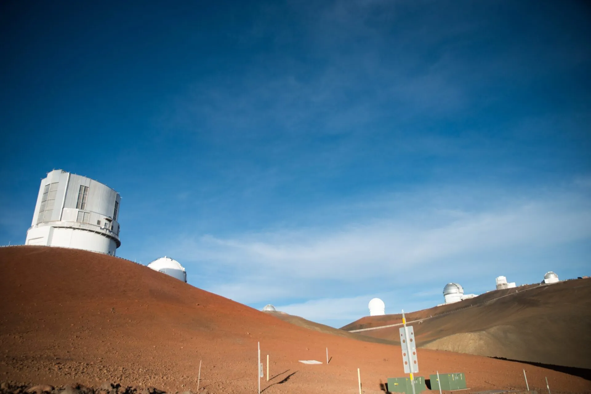 赤い火山土の上に建つすばる望遠鏡と天文台群
