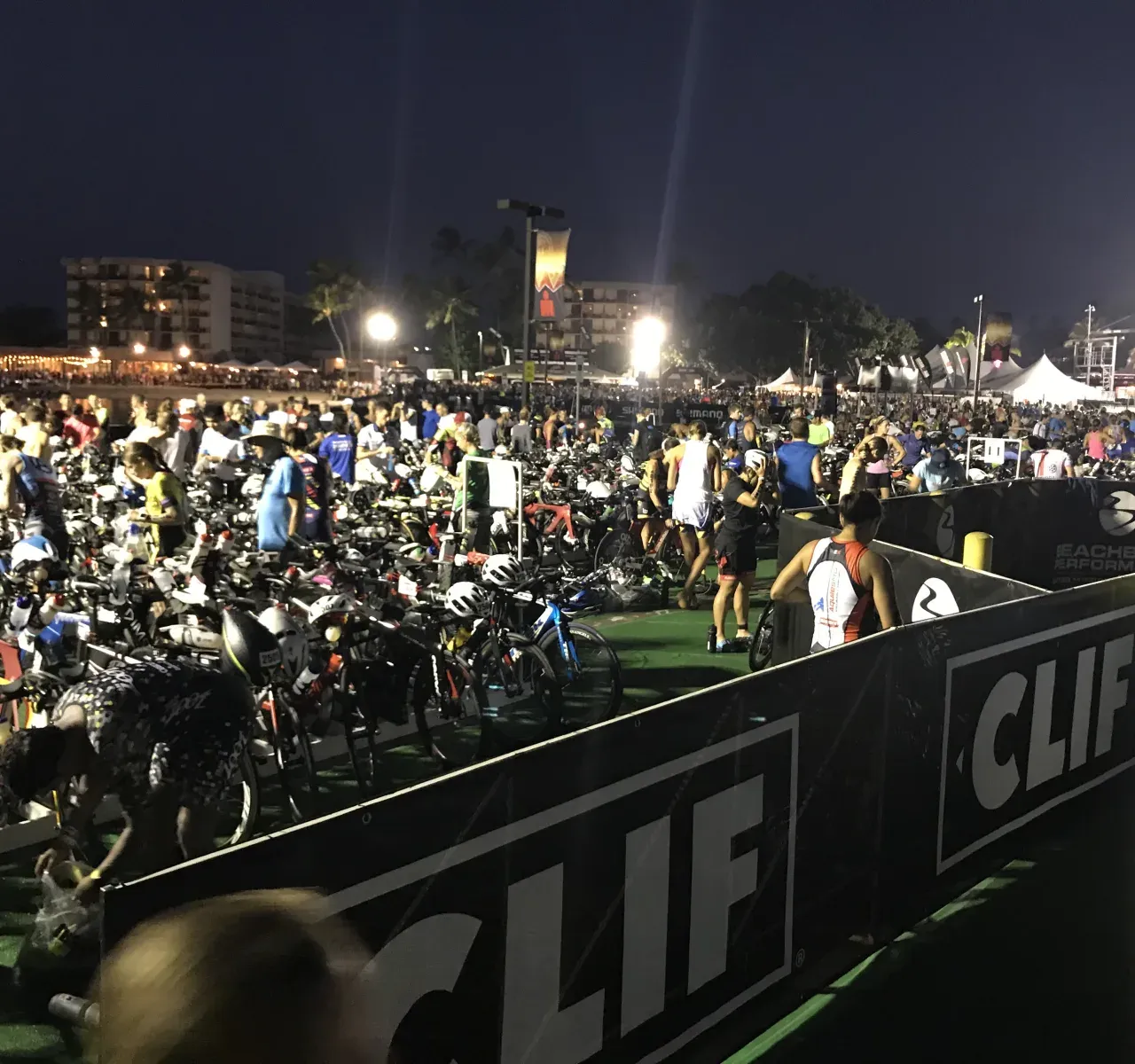 夜明け前のトランジションエリア。ライトに照らされて選手と機材が動き出すIRONMANの朝の景色