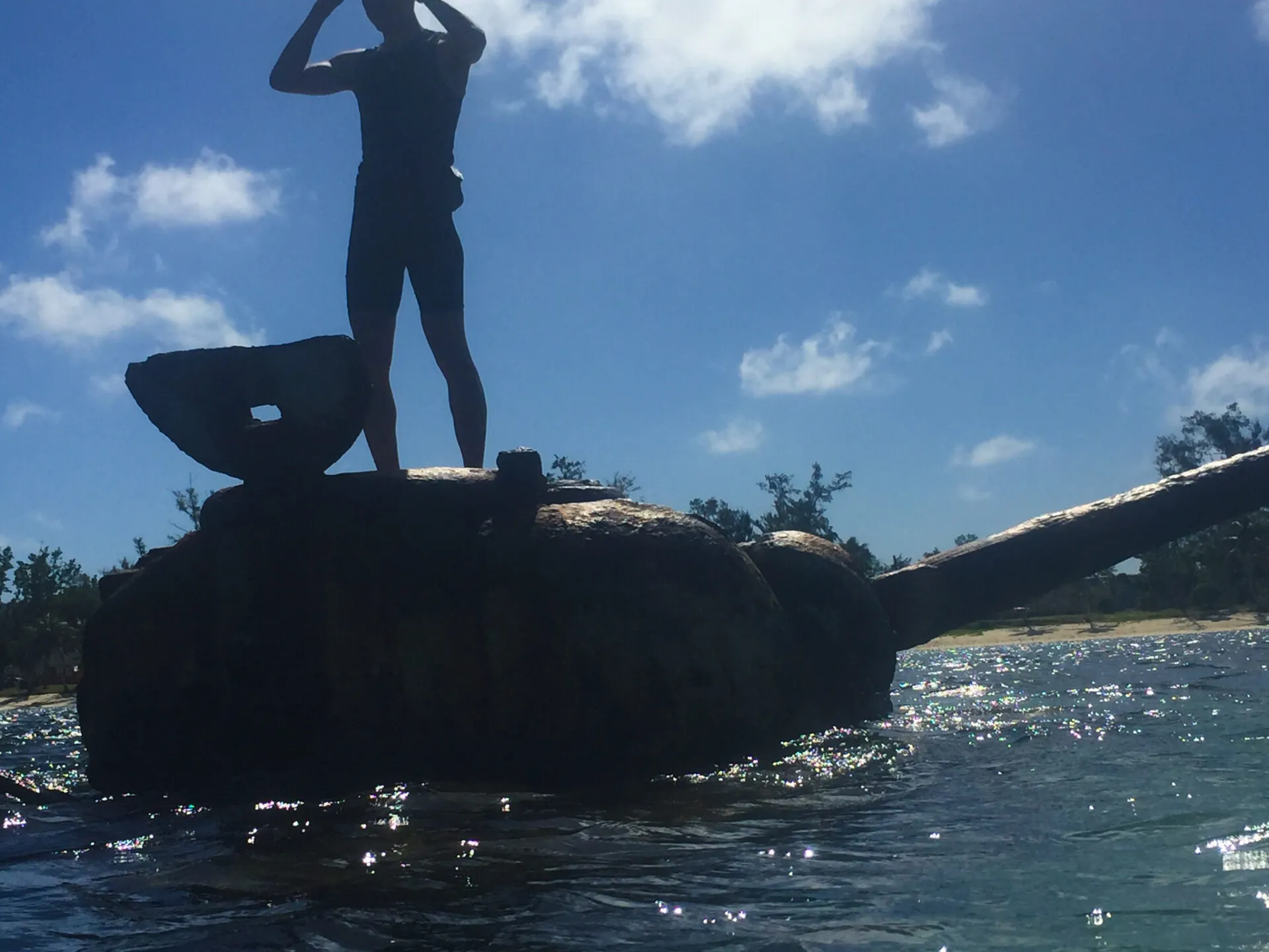 海に沈む戦車の上に立つシルエット