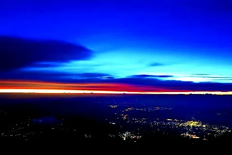 富士山頂からの夜明け、街の灯りとオレンジの地平線