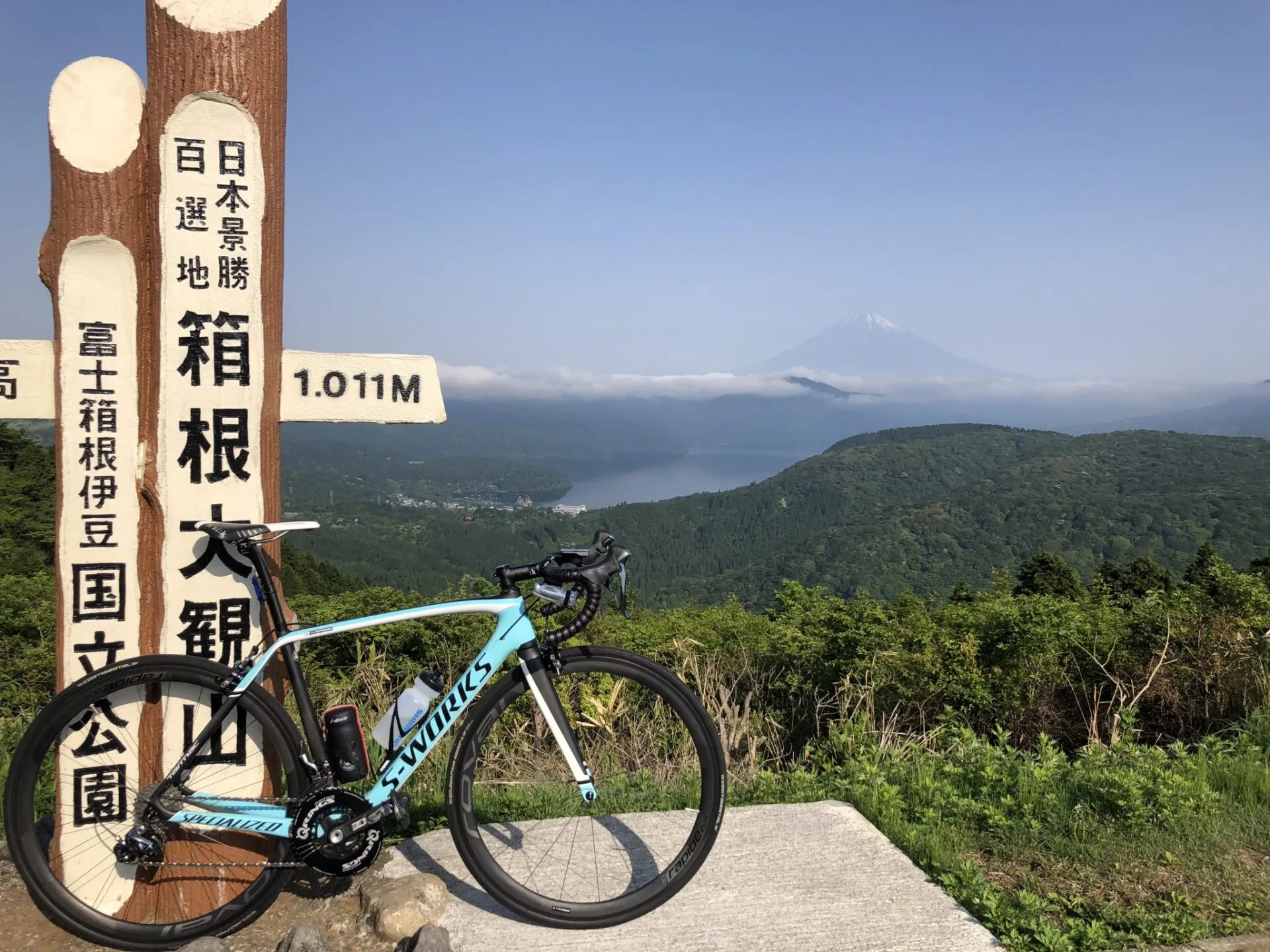 最高地点の標識とロードバイク、背景に富士山