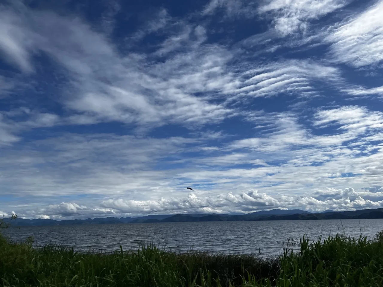 猪苗代湖と鳥が飛ぶダイナミックな雲の空