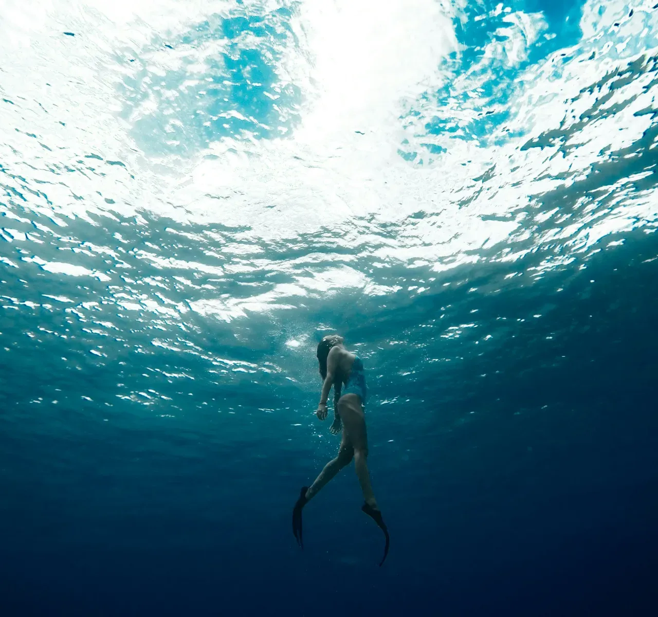 水中から見上げた泳ぎのイメージ。抵抗を減らした泳ぎは、水に溶け込むように進む感覚がある