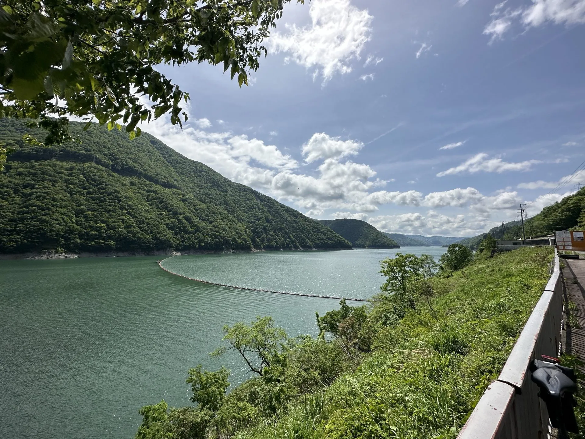 エメラルドグリーンの貯水湖と山々