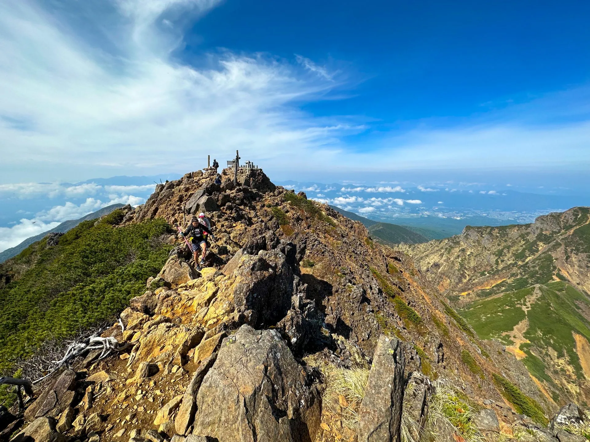 岩稜を歩く登山者、雲海と青空