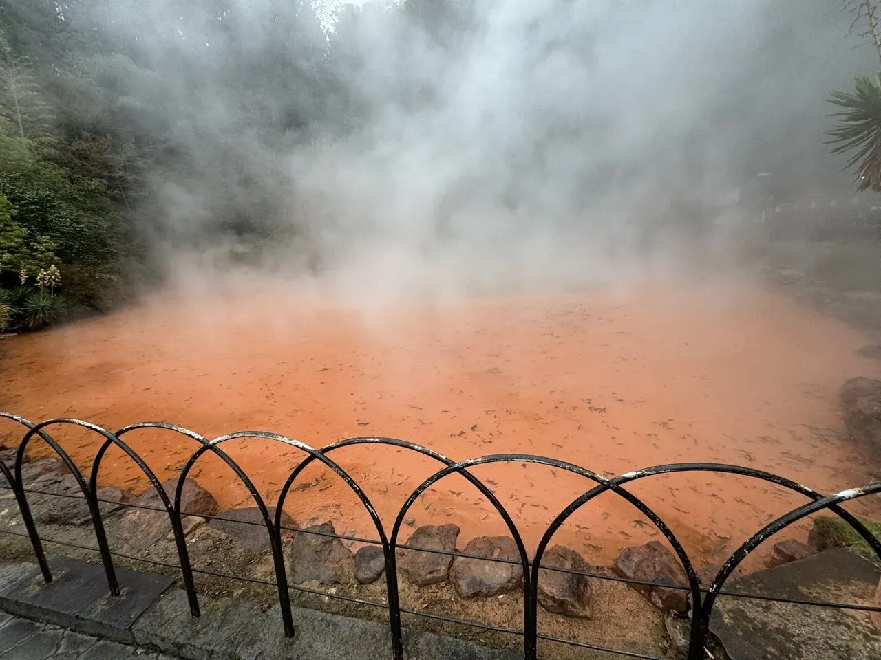 真っ赤な温泉から立ち上る蒸気